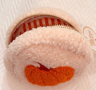 A small plush pumpkin teddy pouch, featuring a soft fuzzy outer shell that has an embroidered pumpkin cenered on it, and a striped orange-and-white interior lining with a gold zipper.